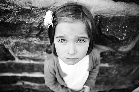 grayscale photo of girl leaning on brick wall thumbnail