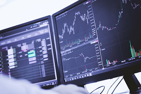 Trader working on pc with graphs and diagrams on monitor thumbnail
