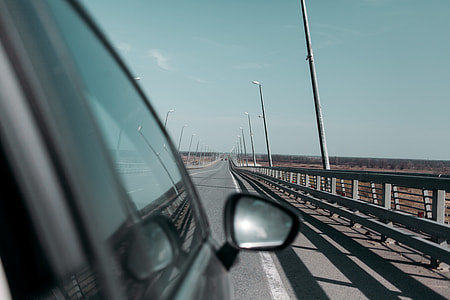 black vehicle traveling on road at daytime thumbnail