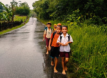 five children walking on gray concrete road thumbnail