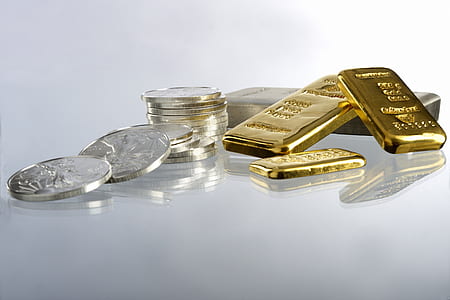 round silver-colored coin and gold bar on surface thumbnail