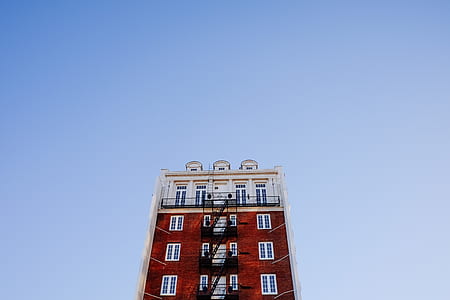 worm's eye view photo of red and white building during daytime thumbnail