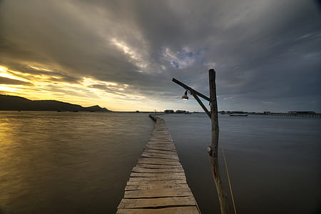 brown wooden dock taken at golden hour thumbnail