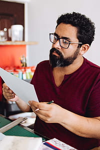 man holding paper while reading thumbnail