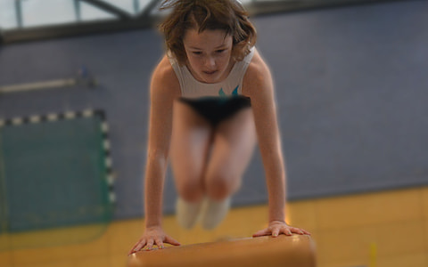 woman jumping on balance beam thumbnail
