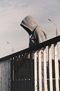 man standing beside black and white rail thumbnail