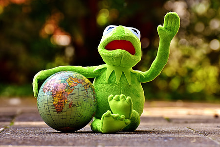 Kermit the frog with deskglobe on concrete ground thumbnail