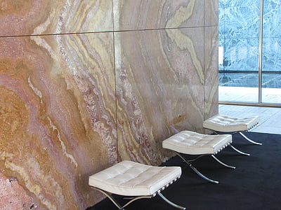 three tufted white ottomans beside wall thumbnail