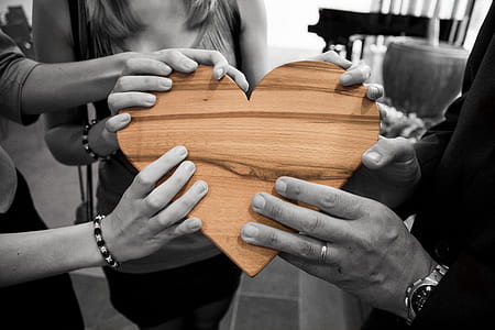 people holding brown wooden heart slab thumbnail