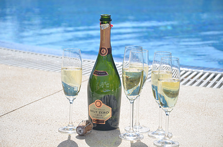 wine bottle and wine glasses near pool thumbnail