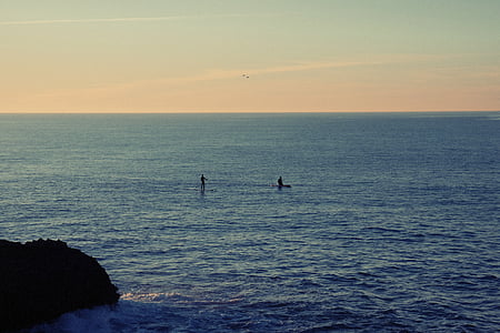 silhouette of two person on board on sea thumbnail