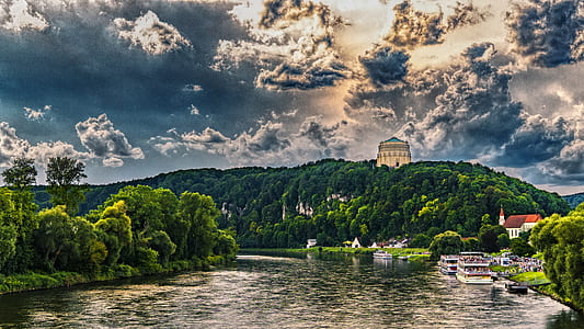lake near mountain under cloudy sky at daytime thumbnail