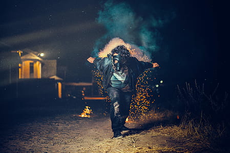 man wearing black mask running on field during nighttime thumbnail