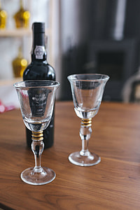Two empty wine glasses with a bottle of wine on a table thumbnail