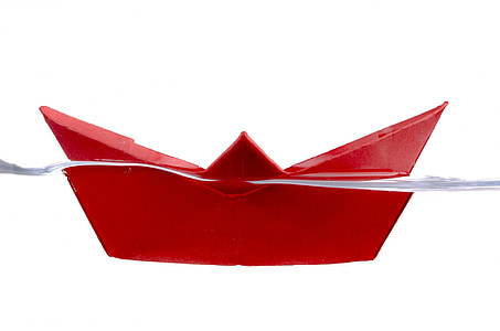 red paper boat origami on water thumbnail
