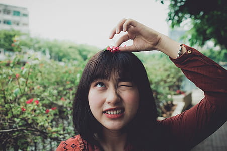 Woman Wearing Red Long-sleeved Shirt With Red Petaled Flower on Head thumbnail
