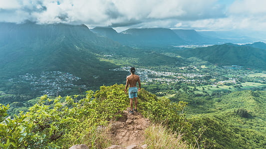 man standing on mountain during daytime thumbnail