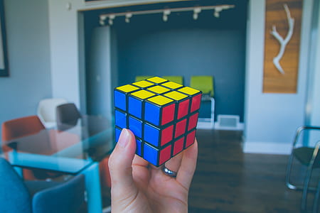 selective focus photography of person holding Rubik's Cube thumbnail