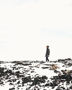 man standing on snow covered mountain during daytime thumbnail