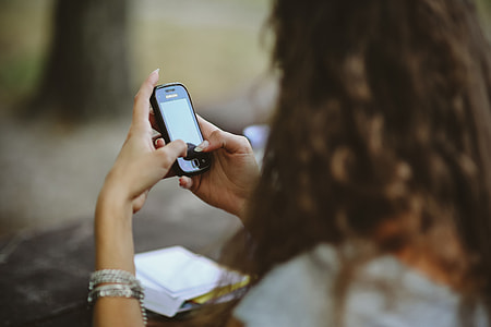 Young woman holding the white mobile phone thumbnail
