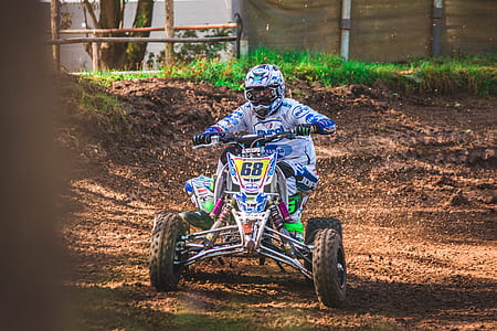 man riding on ATV quad bike dirt road thumbnail