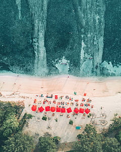 aerial photo of patio umbrellas and lounger near seashore thumbnail
