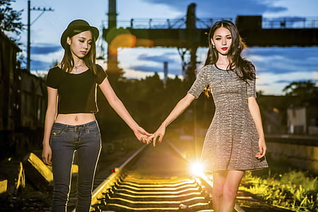 two girls holding hands on railway thumbnail