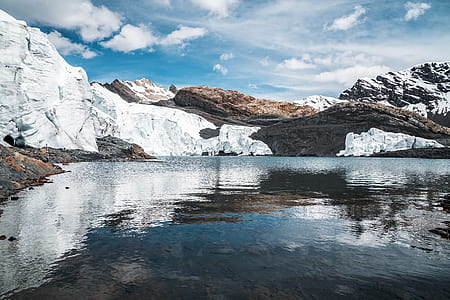 mountain covered with snow near body of water landscape photography thumbnail