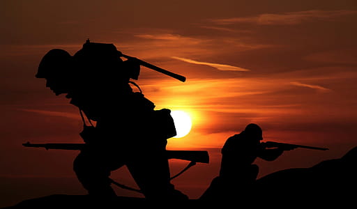 Silhouettes of soldiers against sunset of battlefield. thumbnail