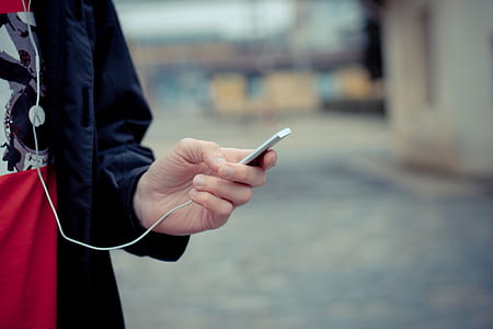 selective focus photography of person holding MP3 player thumbnail