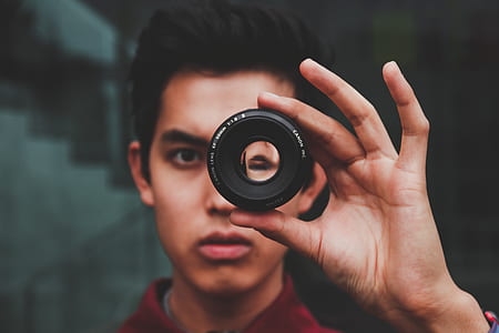 man peeking on camera lens thumbnail