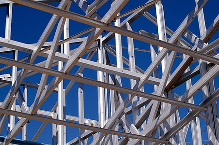 architectural photo of grey metal building frame under blue sky thumbnail