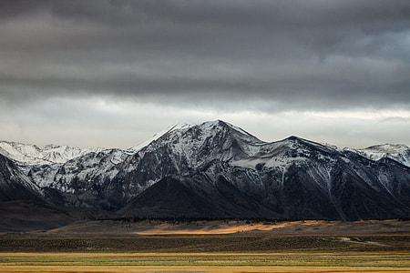 mountain covered with snow under dark clouds thumbnail