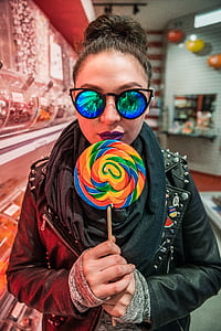 portrait photography of woman holding sugar lollipop thumbnail