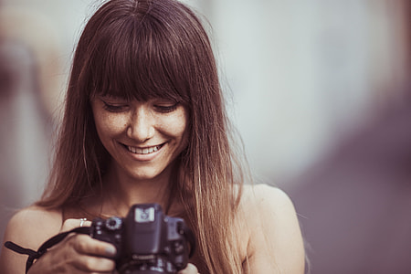 selective focus photography of woman smiling looking picture DSLR camera thumbnail