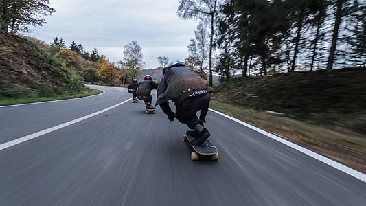 group of people riding longboard on road thumbnail