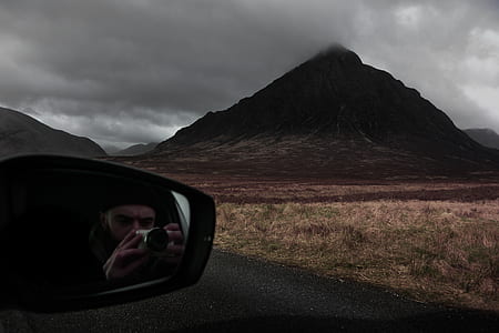 person taking picture inside vehicle under cloudy sky thumbnail