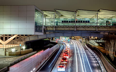vehicles lined up on pathway beside biulding thumbnail