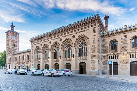 white cars parking in front of brown building during daytime thumbnail