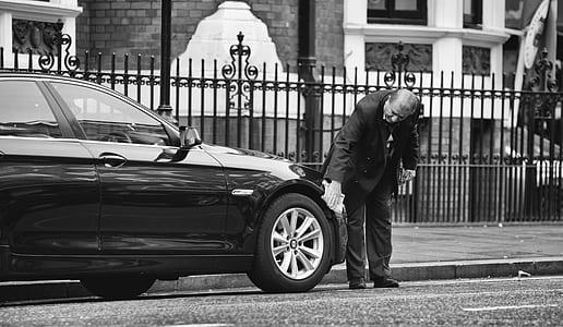 man standing in-front of car grayscale photo thumbnail