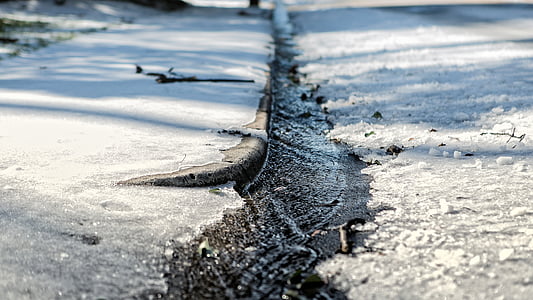 close-up photography of flowing water between concrete road thumbnail
