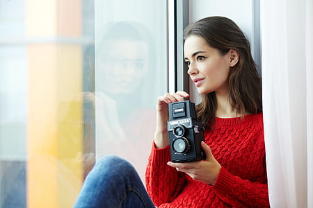 Woman Wearing Red Knitted Shirt Holding Instant Camera thumbnail