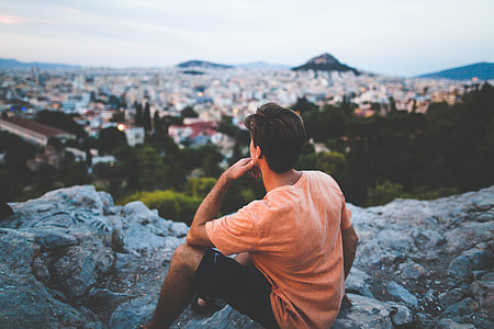 man sitting on gray rock thumbnail