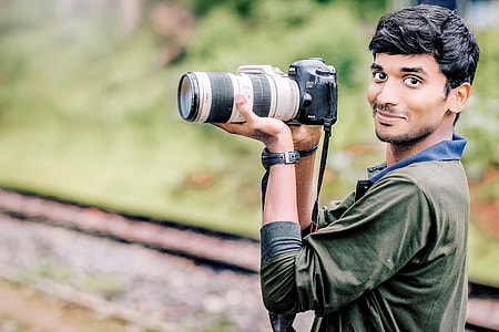 person holding black Canon EOS DSLR camera thumbnail