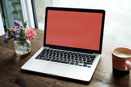 turned on MacBook Pro beside mug thumbnail