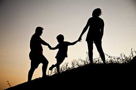 silhouette of family on hill during twilight thumbnail