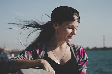 Selective Focus Photography of Female Wearing Black Snapback Near Ocean thumbnail