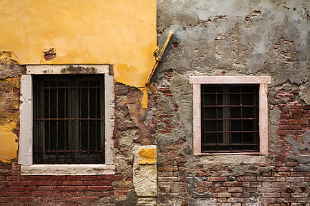 gray and brown concrete building with two windows thumbnail
