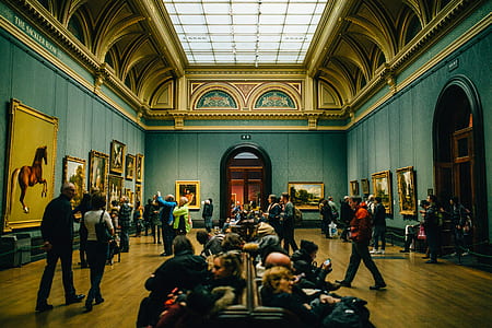 People Walking on Wooden Floor Inside Green Walled Building thumbnail
