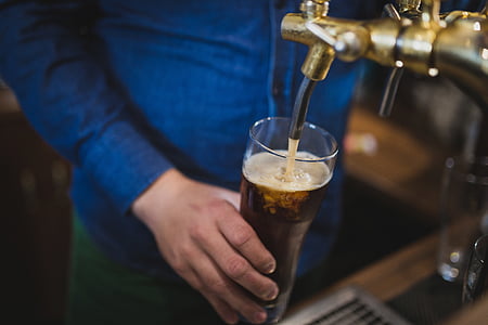 person holding glass while getting soda on dispenser thumbnail